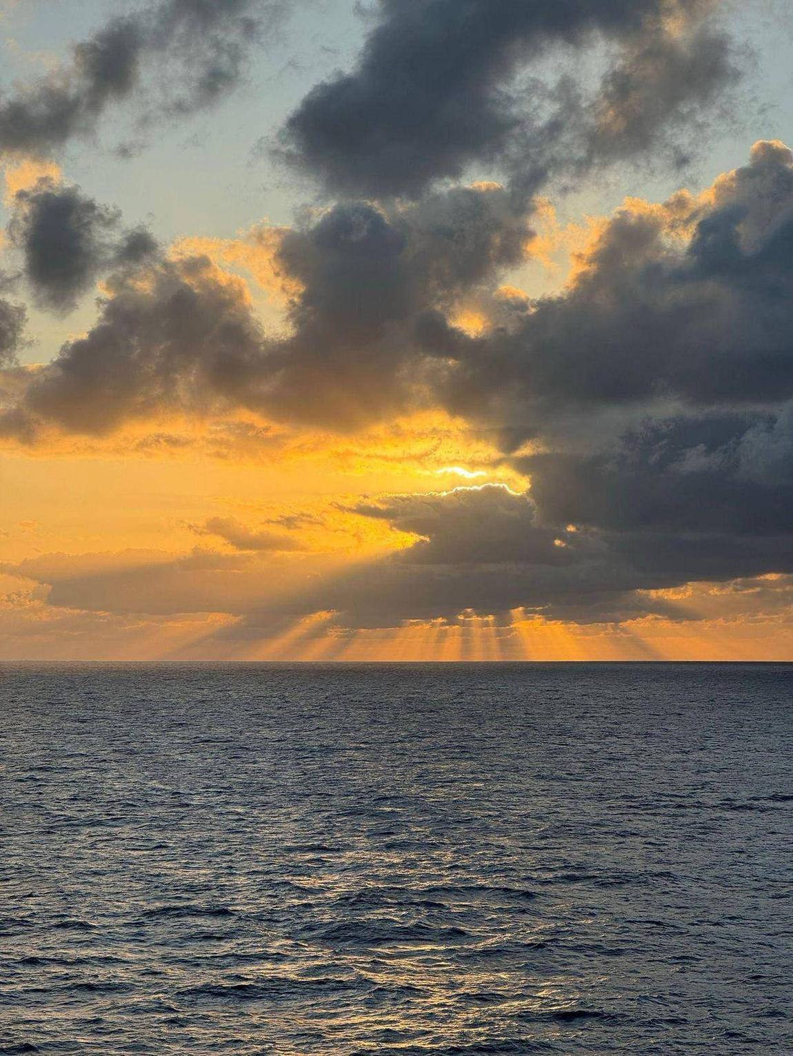 Golden sunrise breaking through clouds, representing hope for change